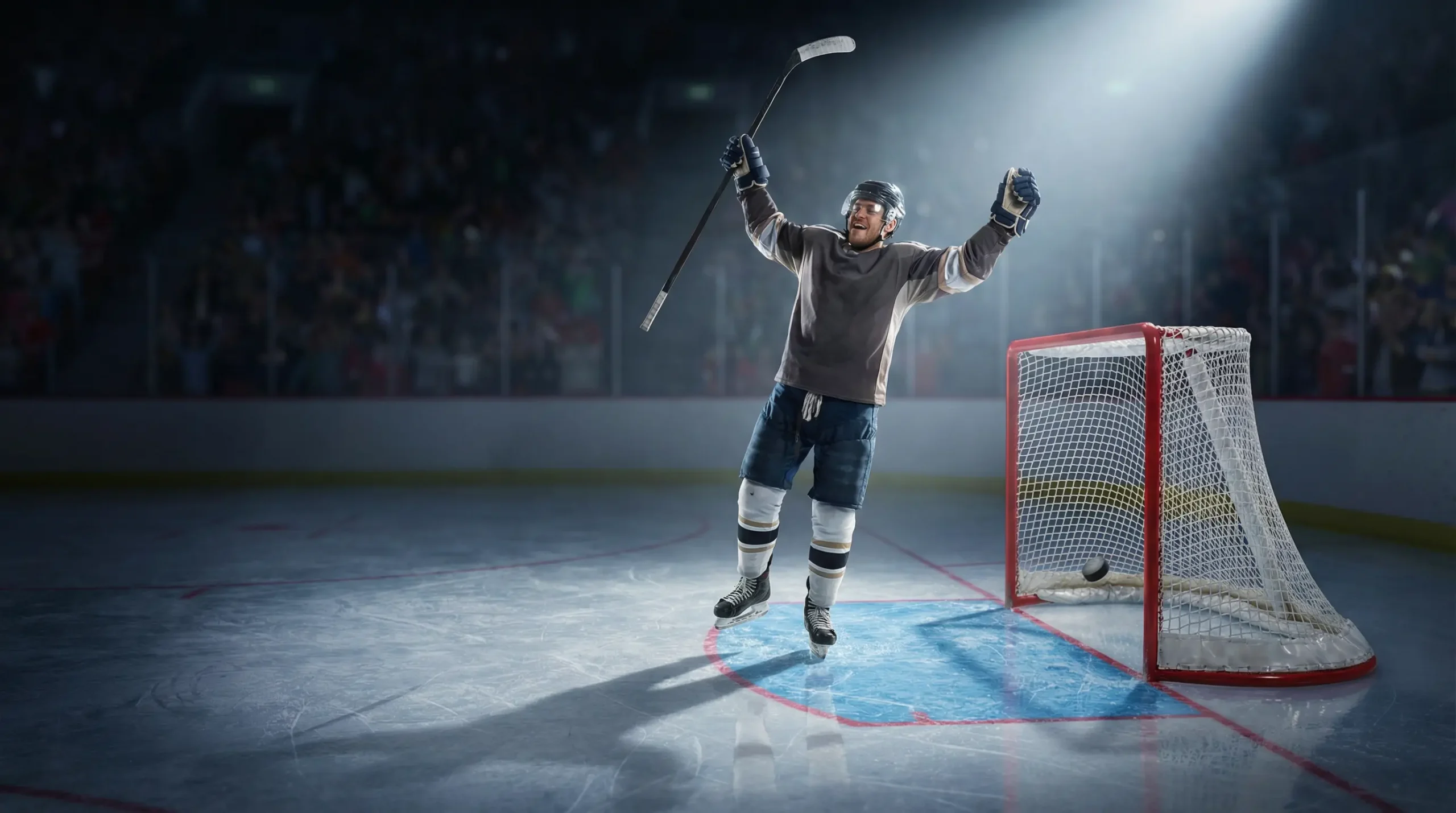 Joueur de hockey outsider célébrant un but sur la patinoire sous les lumières de l'aréna